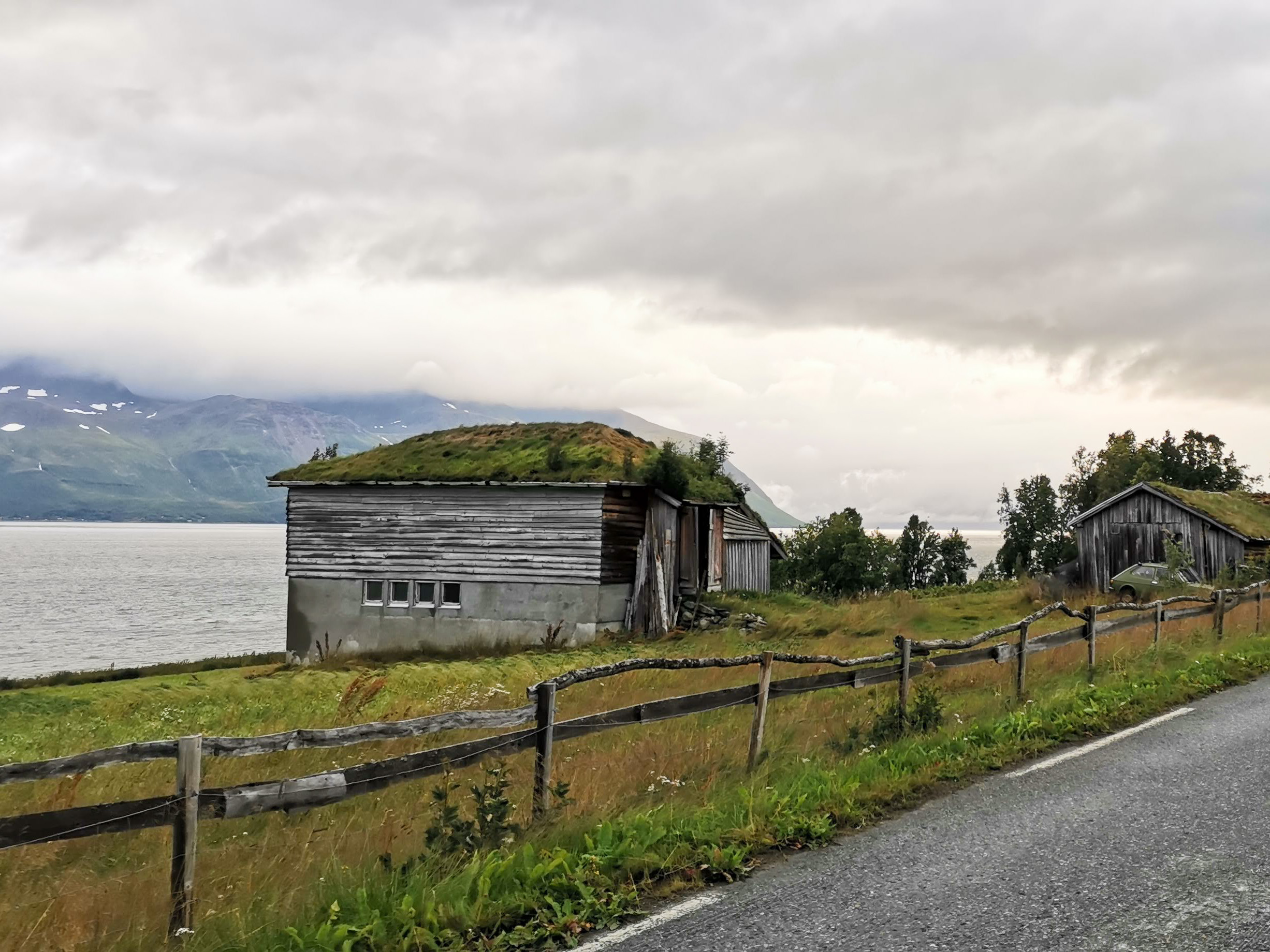Norjan maaseutumaisemassa sammalkattoinen lato. 